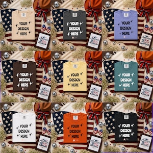 May include: A collection of nine folded t-shirts in various colors including beige, charcoal, light purple, brown, yellow, teal, white, orange, and black. Each shirt features the text YOUR DESIGN HERE with star icons and a small logo at the bottom.
