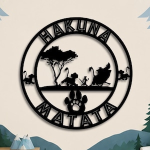 May include: A circular black metal wall art piece featuring a silhouette of a lion cub, a meerkat, and a warthog walking under a tree. The text HAKUNA MATATA is cut into the circular frame, with a large animal paw print centered at the bottom.
