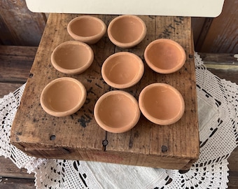 A set of 8 unglazed terracotta mini seed pots.