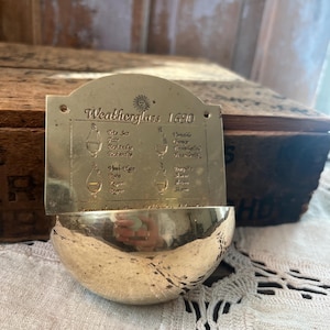 A brass vintage-style weather glass barometer, also known as a storm glass or water barometer