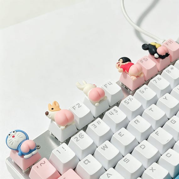 A hand-cast artisan resin keycap shaped like a tiny cartoon butt — absurdly specific, surprisingly well-crafted, and guaranteed to make anyone glance twice at your keyboard.