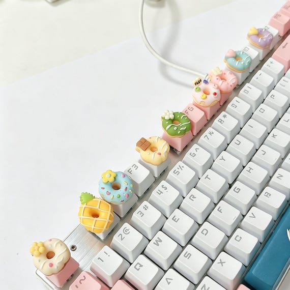 A tiny, hyper-detailed hand-sculpted donut sitting on your keyboard — resin artisan keycaps like this are a whole collector subculture and this one is genuinely adorable.