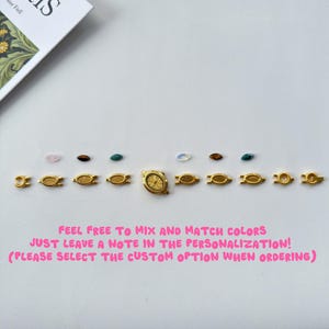 May include: A gold-toned watch face and various oval-shaped metal link components arranged in a row, accompanied by small, colorful, marquise-cut gemstones. The text reads: FEEL FREE TO MIX AND MATCH COLORS JUST LEAVE A NOTE IN THE PERSONALIZATION! (PLEASE SELECT THE CUSTOM OPTION WHEN ORDERING)