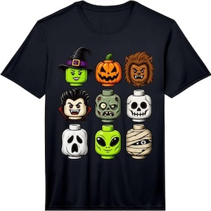 May include: A black short-sleeve t-shirt featuring a graphic print of nine stylized Halloween character heads arranged in a grid. The characters include a witch, pumpkin, werewolf, vampire, zombie, skeleton, ghost, alien, and a mummy figure.