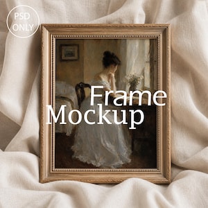 May include: A rectangular gold-toned picture frame with a beaded inner edge detail. The frame contains an oil painting of a person in a white dress sitting at a table near a window. The text PSD ONLY and Frame Mockup are overlaid on the image.