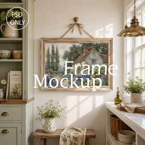 May include: A rectangular wooden picture frame hanging by a ribbon, displaying a landscape painting of a stone cottage with a garden. The frame is centered on a wall above a wooden bench, with text overlay reading PSD ONLY Frame Mockup.