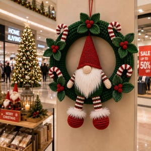 Peut inclure: Une couronne de Noël crochetée vert foncé avec un gnome central portant un bonnet rouge, une barbe blanche et des jambes rayées. La couronne est ornée de feuilles de houx, de baies rouges et de sucres d'orge rayés rouge et blanc.
