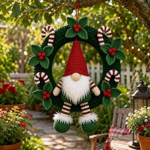 May include: A dark green crocheted wreath decorated with red and white striped candy canes and clusters of green leaves with red berries. A crocheted gnome with a red hat, white beard, and striped legs hangs from the center of the wreath.