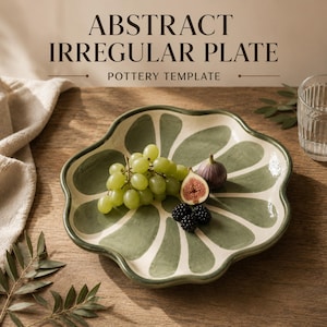 May include: An irregular, scalloped-edge ceramic plate featuring a cream-colored base with a painted green petal pattern. The text 'ABSTRACT IRREGULAR PLATE POTTERY TEMPLATE' is printed above the plate, which holds green grapes, a fig, and blackberries.