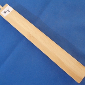 May include: A wooden dowel rod with a rounded end, measuring 8-1/2 inches in length. The dowel is light brown in color and has a smooth surface.