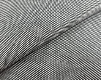 May include: Close-up of a textured fabric with a woven pattern. The fabric is a mix of black and white threads, creating a speckled appearance. The material is folded, showing the texture and drape of the fabric. Ideal for upholstery or clothing.
