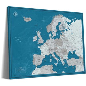 May include: A rectangular wall map of Europe featuring a deep teal ocean background and light gray landmasses. The map includes a compass rose in the top left corner and a text box in the bottom left corner labeled Europe Travels.