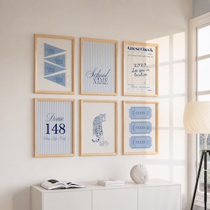 May include: Six framed wall art prints in light wood frames. The prints feature blue and white designs including pennants, vertical stripes, a guest check, the text Dorm 148, a leopard illustration labeled School Mascot, and three state tickets.