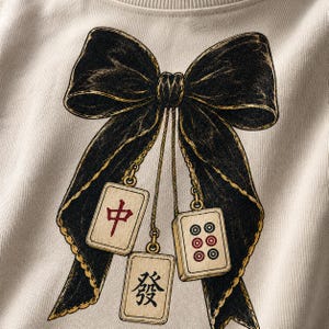 Coquette Mahjong PNG featuring a vintage black bow, hanging Mahjong tiles, crescent moons and Mahjong After Dark typography.