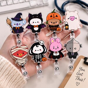 May include: Eight acrylic badge reels featuring Halloween-themed characters including a koala witch, a bat, a pumpkin, a ghost, a mummy, a skeleton, a vampire rabbit, and a Frankenstein monster. Each character is attached to a retractable cord.