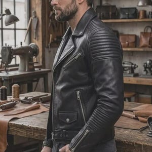 May include: A black leather motorcycle jacket featuring a notched lapel, silver-tone metal zippers on the chest and cuffs, a small snap-button flap pocket, and ribbed quilted detailing on the shoulders and upper sleeves with an adjustable waist belt.