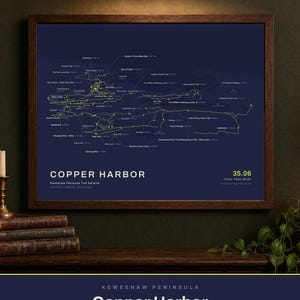 May include: A framed map print of the Copper Harbor Keweenaw Peninsula Trail Network in Michigan. The dark blue background features yellow lines representing 42 named trails, totaling 35.06 miles, with text labels for each trail and location.