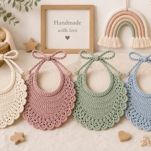 Pode incluir: Quatro babadores de crochê para bebê nas cores creme, rosa antigo, verde sálvia e azul claro. Cada babador apresenta uma borda festonada, um centro sólido e duas longas tiras de crochê no topo que formam um laço.
