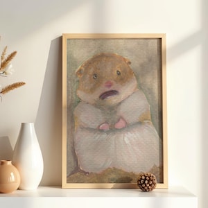 May include: A framed watercolour painting of a hamster with brown fur on its head and white fur on its body. The hamster has a small pink nose, dark eyes, and a slightly open mouth. The artwork is enclosed in a light-coloured wooden frame.