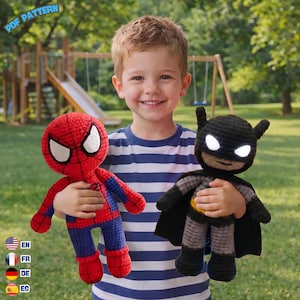 May include: Two handmade crochet dolls featuring a red and blue superhero with a web pattern and a black superhero with a cape and white eyes. The image includes the text PDF PATTERN in the top left corner and language flag icons.