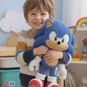 May include: A blue crochet plush toy of the character Sonic, featuring a tan muzzle and belly, white gloves, and red and white trainers with grey soles. The plush has large green eyes, a black nose, and pointed ears with tan inner details.