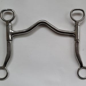 Op de afbeelding: Een zilverkleurig metalen paardenbit met een hooggepoort mondstuk met een gebogen boog in het midden. Het bit is voorzien van twee lange scharen met ringen aan de boven- en onderkant, ontworpen voor hefboomwerking en controle tijdens het rijden.
