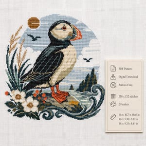 Puede incluir: Un patrón de punto de cruz con un frailecillo sobre una roca, rodeado de flores blancas y hierba alta. El diseño incluye un fondo costero con sol, aves y olas. El texto indica PDF Pattern, 150 x 152 puntadas, 20 colores y dimensiones para tela de 14, 16 y 18 ct.