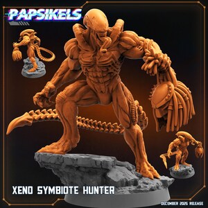 May include: An orange-toned Xeno Symbiote Hunter miniature figure standing on a gray rocky base. The creature features a long tail, muscular build, and an elongated head, holding a severed helmeted head in its left hand. Text reads PAPSIKELS.