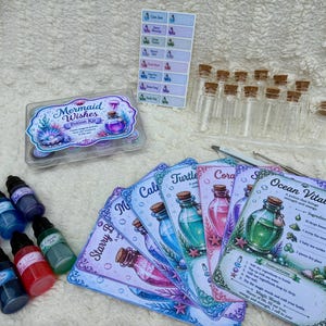 May include: A Mermaid Wishes potion kit featuring a clear plastic box, a sheet of small rectangular labels, ten empty glass vials with cork stoppers, a metal stirring tool, seven small bottles of coloured liquid, and several illustrated recipe cards.