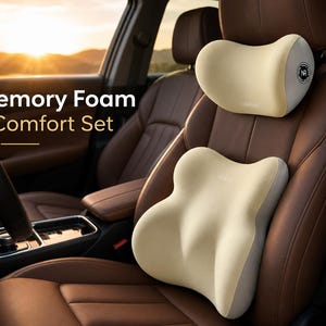 May include: A memory foam comfort set consisting of a contoured headrest pillow and a lumbar support cushion, both in a light beige color with grey side panels. The headrest features a circular logo with the letters NR. Text reads Memory Foam Comfort Set.