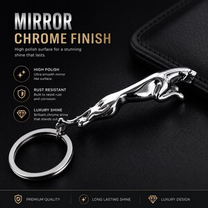 May include: A silver-colored metal keychain featuring a leaping jaguar figurine with a mirror chrome finish. The keychain includes a circular split ring attached to the base of the animal figure, which has a smooth, reflective surface.