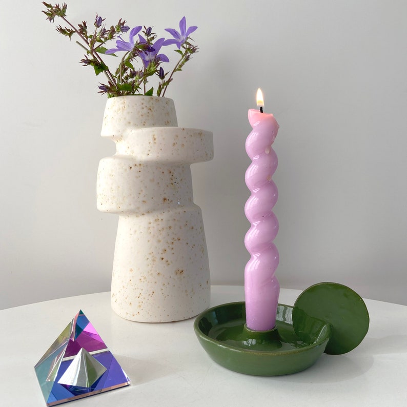 Handmade candleholder with disc shaped handle glazed in a bright bottle green. The shape of this candleholder is minimalistic and looks great in a Scandinavian style interior. The colour is a nice touch to add to your colourful style.