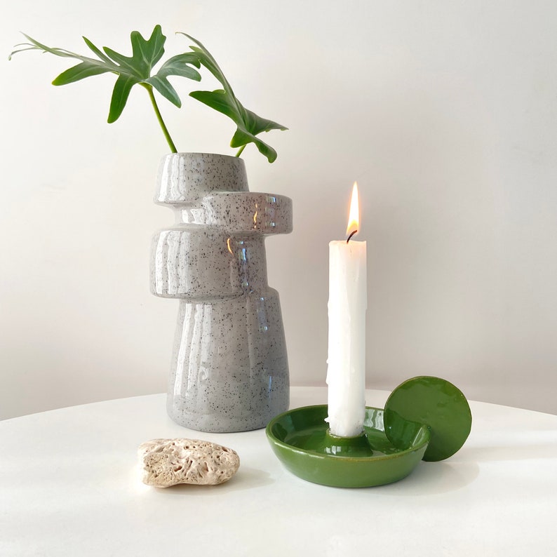 Handmade candleholder with disc shaped handle glazed in a bright bottle green. The shape of this candleholder is minimalistic and looks great in a Scandinavian style interior. The colour is a nice touch to add to your botanical style.