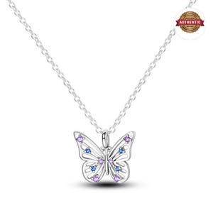 Può includere: Una collana con ciondolo a forma di farfalla in argento con dettagli traforati sulle ali, impreziosita da piccole gemme viola e blu. Il ciondolo è appeso a una sottile catenina d'argento. Un bollino circolare riporta 100% AUTHENTIC SILVER ORIGINAL.