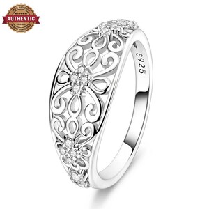 May include: A silver ring featuring an intricate filigree pattern with openwork scroll designs and small embedded clear stones. The inner band is clearly stamped with the text S925, indicating the metal composition of this polished silver jewelry piece.