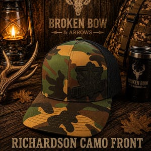Può includere: Un cappellino da baseball con stampa mimetica, retro in rete nera e una toppa nera sul davanti con il testo BROKEN BOW. Il cappello ha un pannello frontale strutturato e una visiera curva. Il testo RICHARDSON CAMO FRONT BLACK BACK FLEX FIT HAT è visibile.