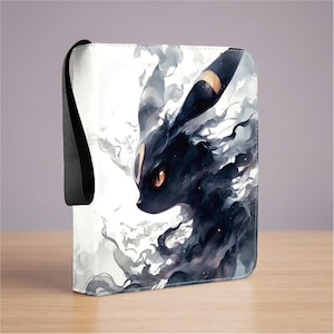 Puede incluir: Una carpeta rectangular con cremallera que presenta una ilustración artística en blanco y negro de una criatura oscura con orejas largas, ojos naranjas brillantes y una marca amarilla en la frente, rodeada de patrones de humo.