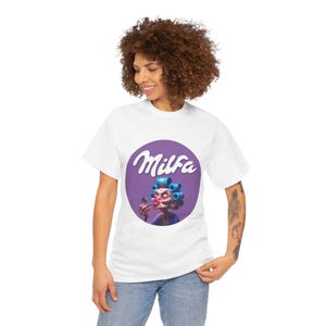 May include: A white short-sleeved t-shirt featuring a circular purple graphic on the chest. The graphic depicts a character with blue hair rollers applying pink lipstick, with the white text Milfa written in a cursive font above the character.