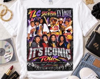 May include: A white crew neck t-shirt featuring a graphic print of the 90s music tour titled It's Iconic Tour, showcasing images of the musical groups TLC, Salt-N-Pepa, and En Vogue with bold, colorful text and a concert crowd silhouette at the bottom.