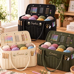 May include: Three rectangular fabric yarn storage bags in black, cream, and olive green. Each bag features an embroidered name, daisy accents, multiple exterior pockets for crochet hooks and scissors, and an interior lid organizer for needles.