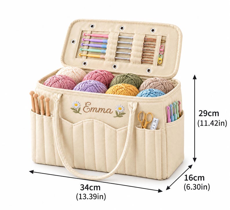 May include: A beige fabric yarn storage bag with the name Emma embroidered between two daisy flowers. It features multiple pockets, internal crochet hook loops, and yarn balls. Dimensions are 34cm (13.39in) wide, 16cm (6.30in) deep, and 29cm (11.42in) high.