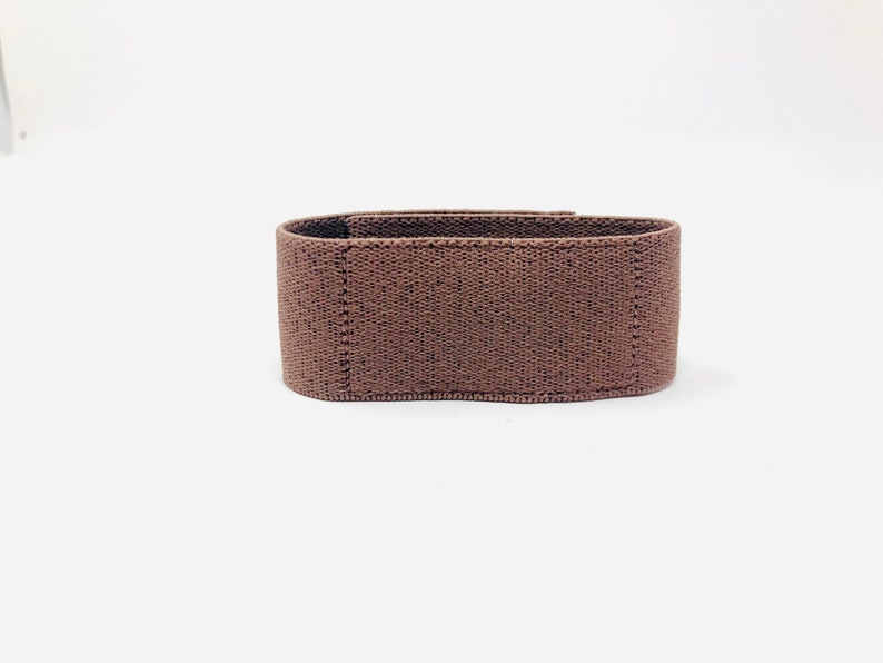 May include: A brown fabric resistance band for exercise.