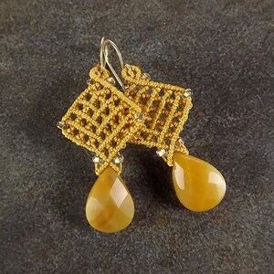 Peut inclure: Une paire de boucles d'oreilles dor&eacute;es avec un design crochet&eacute; et des pierres ambr&eacute;es en forme de larme.