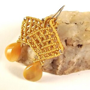 Peut inclure: Boucles d'oreilles en crochet dor&eacute;es avec deux pierres de cornaline en forme de goutte.