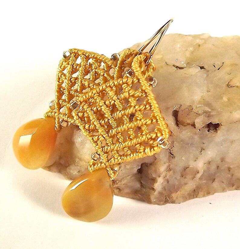 Peut inclure: Boucles d'oreilles en crochet dor&eacute;es avec deux pierres de cornaline en forme de goutte.