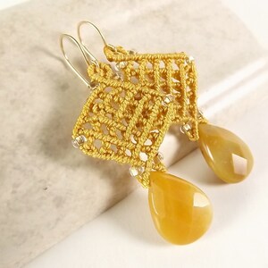 Peut inclure: Une paire de boucles d'oreilles en or avec un motif crochet&eacute; jaune et des pierres jaunes en forme de larme.