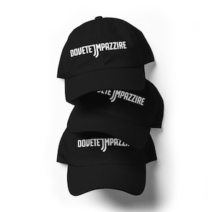 Peut inclure: Une pile de trois casquettes de baseball noires, chacune arborant le texte brodé en blanc DOVETE JMPAZZIRE sur le panneau avant. Les casquettes présentent une calotte structurée, une visière incurvée et un bouton sur le dessus.