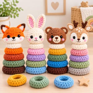 Peut inclure: Quatre jouets à empiler en crochet représentant un renard, un lapin, un ours et un cerf. Chaque tête d'animal repose sur une pile d'anneaux en laine texturée colorée. Trois anneaux en crochet supplémentaires et une étoile en bois sont posés.