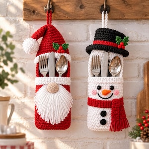 Puede incluir: Dos soportes para cubiertos de ganchillo colgados de ganchos. Uno es un gnomo de Santa Claus rojo con barba y gorro blancos. El otro es un muñeco de nieve blanco con sombrero de copa negro, bufanda roja y nariz naranja. Ambos contienen cubiertos.