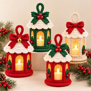 May include: Four crocheted lantern covers with lit candles inside. Each features a white roof, a red or green crocheted body, a decorative bow, and holly berry accents. The lanterns have a top loop for hanging and are arranged in a group.